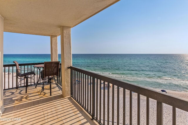 balcony with a water view and a beach view