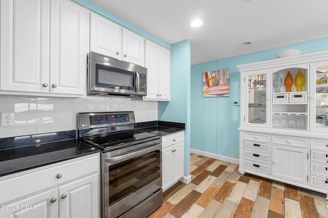 kitchen with light wood-style floors, stainless steel appliances, tasteful backsplash, and white cabinetry