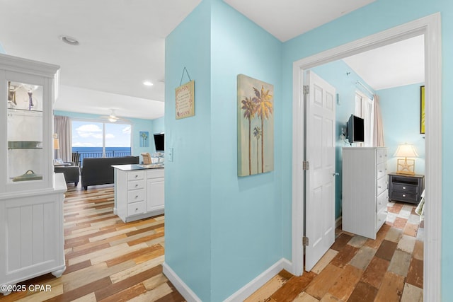 hallway with recessed lighting, light wood-style flooring, and baseboards