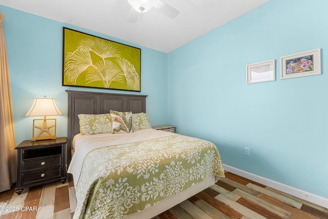 bedroom featuring ceiling fan, baseboards, and wood finished floors