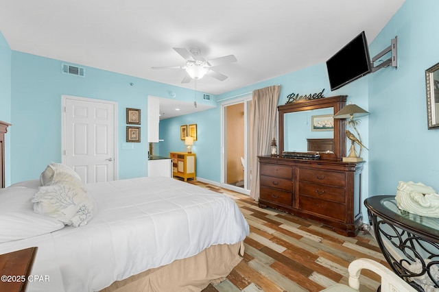 bedroom with visible vents, ceiling fan, and wood finished floors