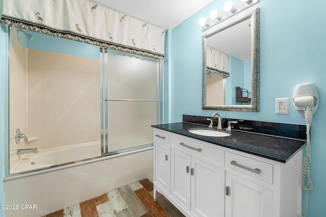 full bathroom with vanity, wood finished floors, and shower / bath combination with glass door