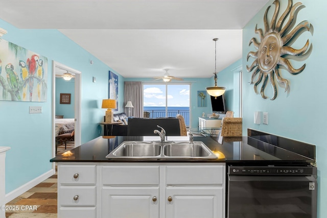 kitchen featuring a sink, black dishwasher, dark countertops, and wood finished floors