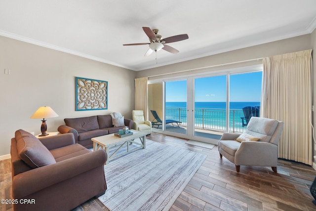 living area with a water view, crown molding, ceiling fan, and wood finished floors