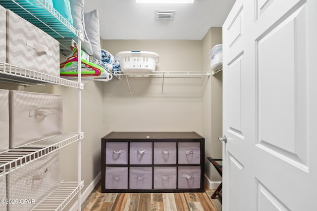 spacious closet featuring visible vents and wood finished floors