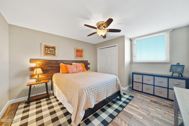 bedroom featuring light wood-style floors, baseboards, and a closet