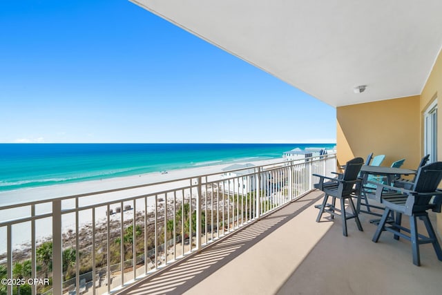 balcony with a water view and a view of the beach