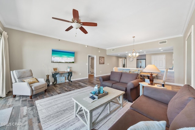 living area featuring crown molding, visible vents, wood finished floors, baseboards, and ceiling fan with notable chandelier