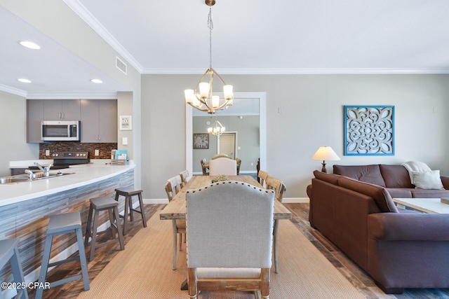 dining area featuring light wood-type flooring, baseboards, visible vents, and a chandelier