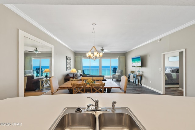 kitchen featuring a notable chandelier, ornamental molding, open floor plan, and a sink