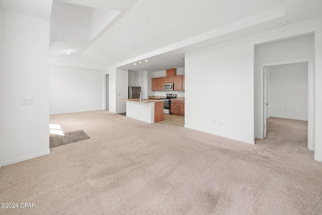 unfurnished living room with light carpet, baseboards, vaulted ceiling, and a sink