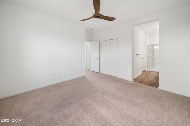 unfurnished bedroom with baseboards, ceiling fan, ensuite bathroom, carpet floors, and a closet