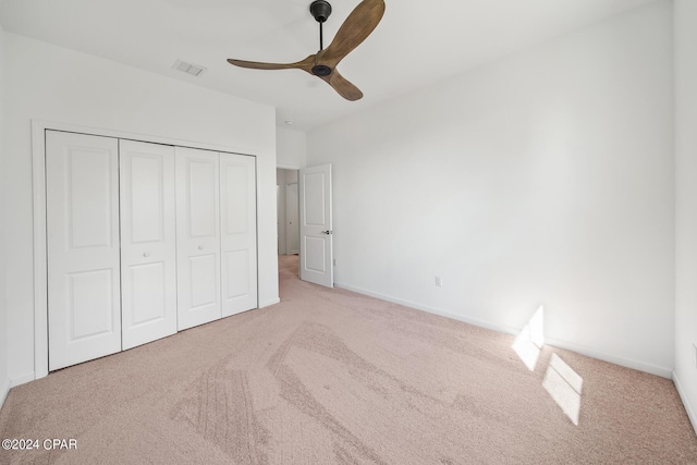 unfurnished bedroom with baseboards, visible vents, a ceiling fan, carpet flooring, and a closet