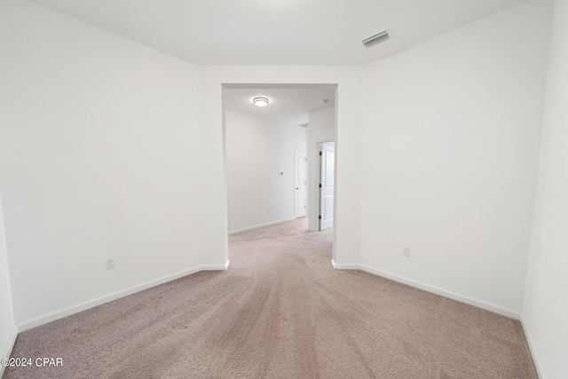 spare room featuring carpet, visible vents, and baseboards