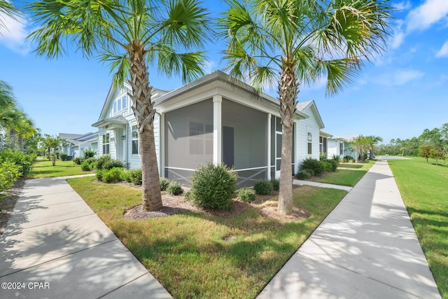 view of property exterior with a sunroom and a lawn