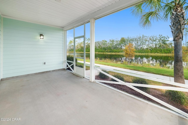 unfurnished sunroom featuring a water view