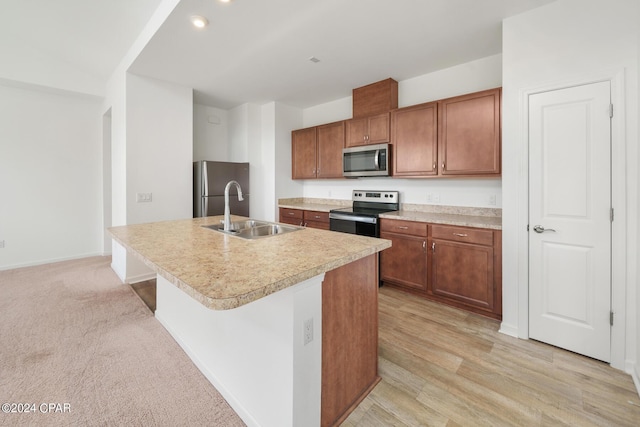 kitchen featuring brown cabinets, appliances with stainless steel finishes, light countertops, and a sink