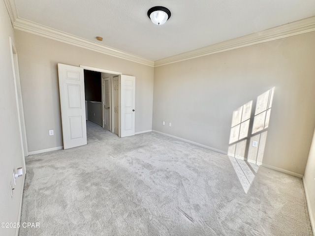 unfurnished room featuring light carpet, baseboards, and ornamental molding