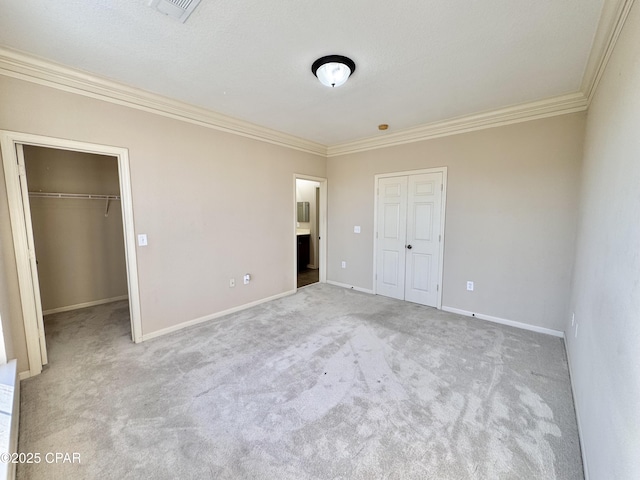 unfurnished bedroom with baseboards, visible vents, a closet, and ornamental molding