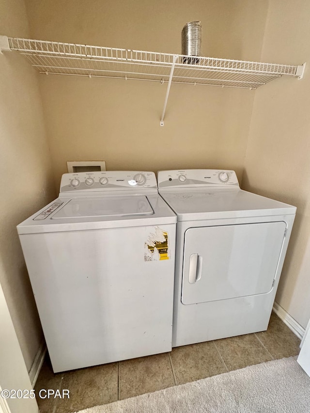 washroom featuring washing machine and dryer, laundry area, and light tile patterned floors