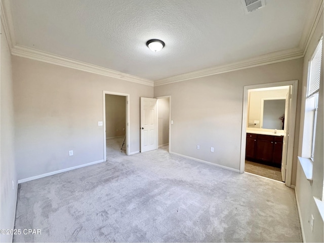 unfurnished bedroom featuring a textured ceiling, light colored carpet, visible vents, baseboards, and ornamental molding