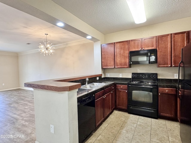 kitchen with dark countertops, ornamental molding, a peninsula, black appliances, and a sink