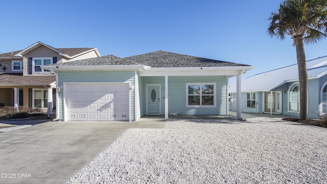 view of front of property featuring concrete driveway, roof with shingles, and an attached garage