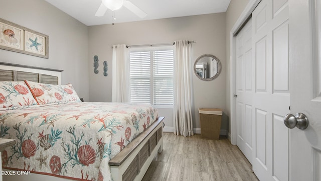 bedroom featuring light wood-type flooring, a closet, ceiling fan, and baseboards