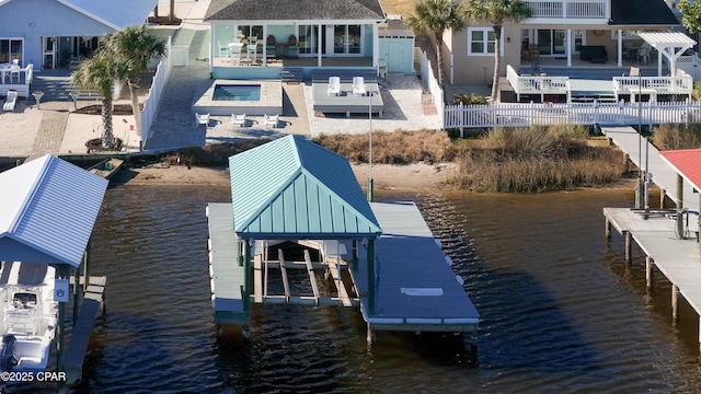 view of dock with a water view, fence, and boat lift