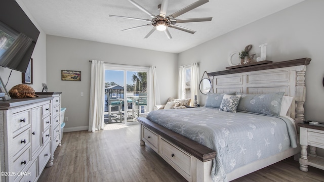 bedroom featuring access to exterior, ceiling fan, baseboards, and dark wood-style flooring