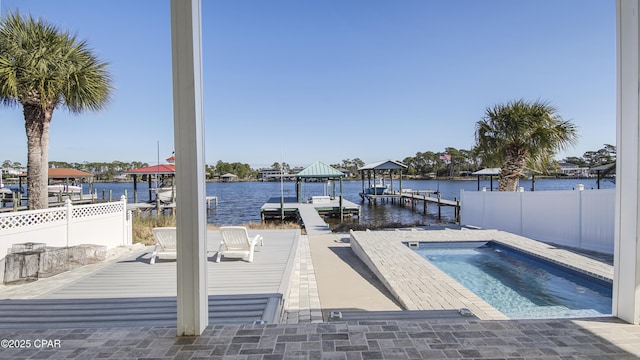 dock area featuring a water view, fence, and a jacuzzi