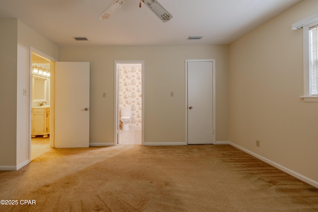 unfurnished bedroom with carpet floors, baseboards, visible vents, and connected bathroom