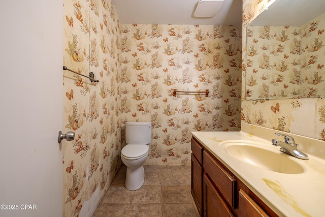 half bathroom featuring toilet, wallpapered walls, tile patterned flooring, and vanity