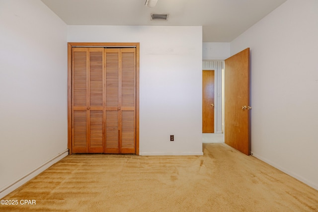 unfurnished bedroom with carpet floors, a closet, and visible vents