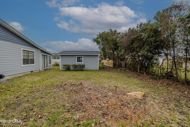 view of yard featuring an outdoor structure and fence