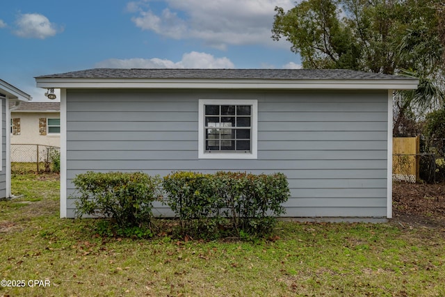 view of side of property featuring fence and a lawn