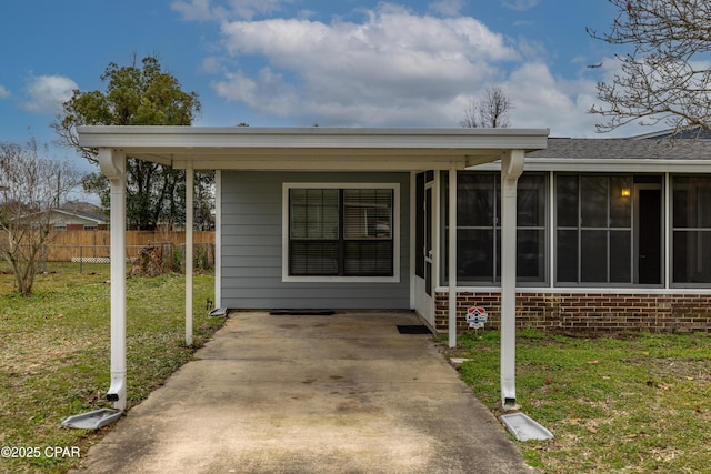 property entrance featuring fence, a lawn, and brick siding