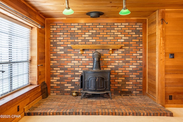 interior details featuring a wood stove, wood ceiling, and wooden walls