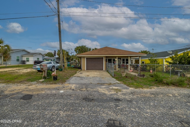 view of front of home featuring a garage, driveway, and fence