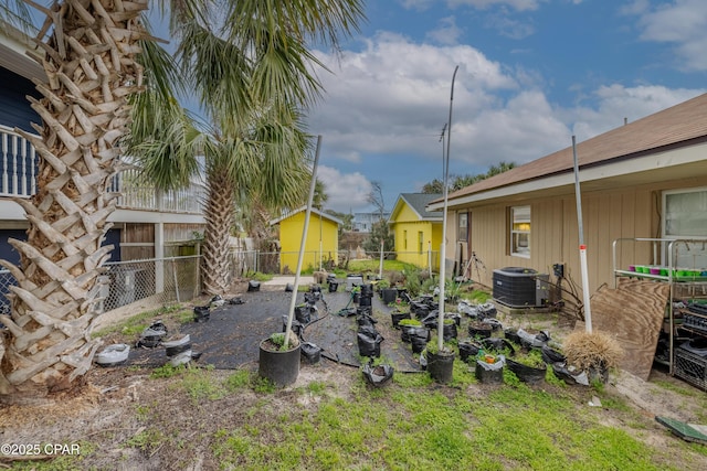 view of yard featuring a vegetable garden, central AC, and fence