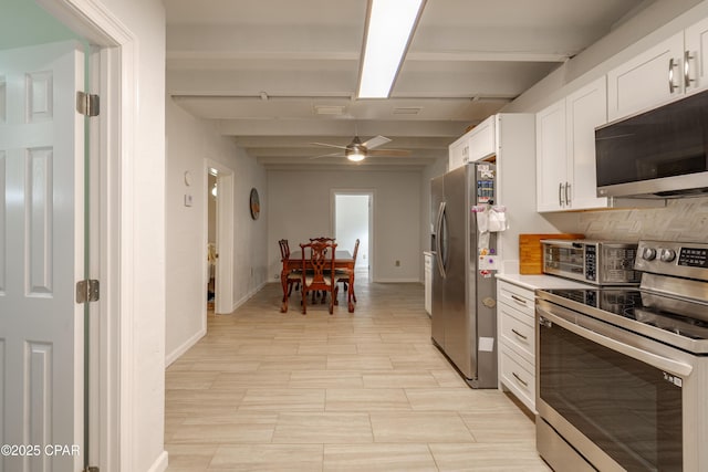 kitchen featuring a toaster, stainless steel appliances, light countertops, a ceiling fan, and white cabinetry