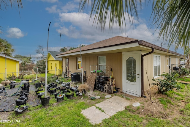 back of house featuring cooling unit and fence