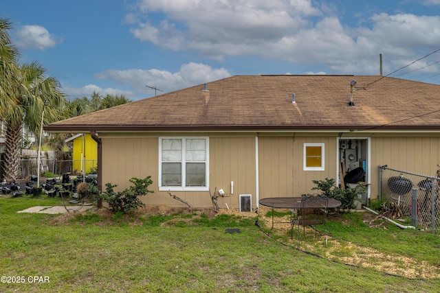 rear view of property with a yard and fence