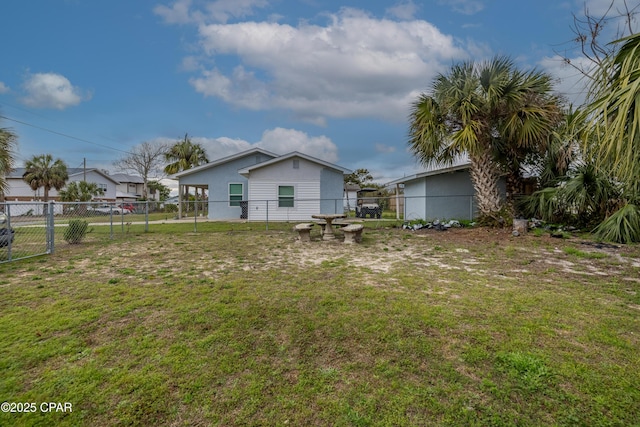 rear view of house with a yard and fence