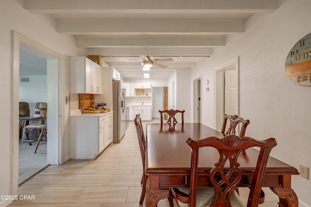 dining room featuring a ceiling fan, visible vents, and beam ceiling