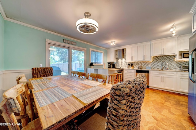 dining room with ornamental molding and wainscoting