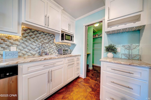 kitchen with a sink, white cabinets, ornamental molding, appliances with stainless steel finishes, and tasteful backsplash