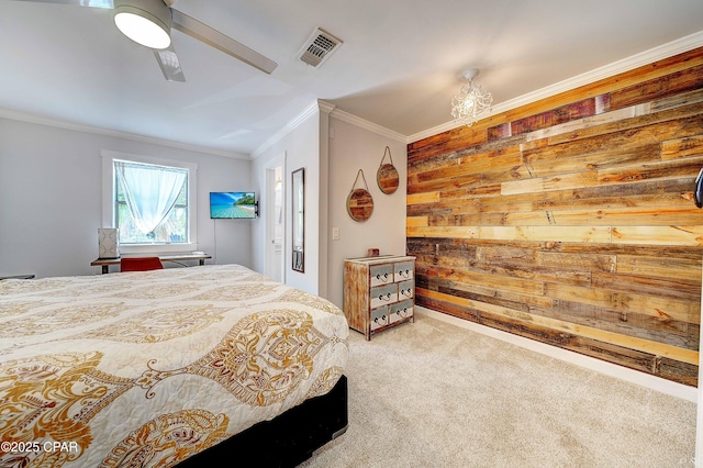 carpeted bedroom with a ceiling fan, wood walls, visible vents, and crown molding