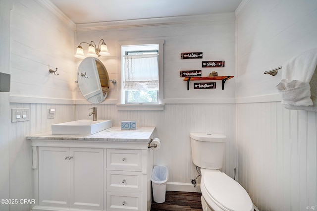 bathroom with ornamental molding, vanity, toilet, and wood finished floors