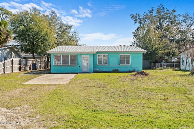 view of front of property with metal roof, a front yard, and fence